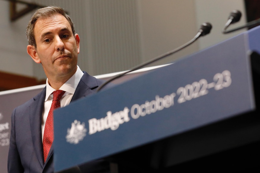 Treasurer Jim Chalmers stands behind a lectern labelled Budget October 2022-23.