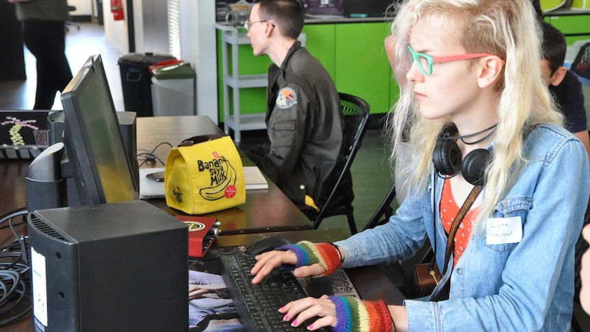 a woman types at a desktop computer