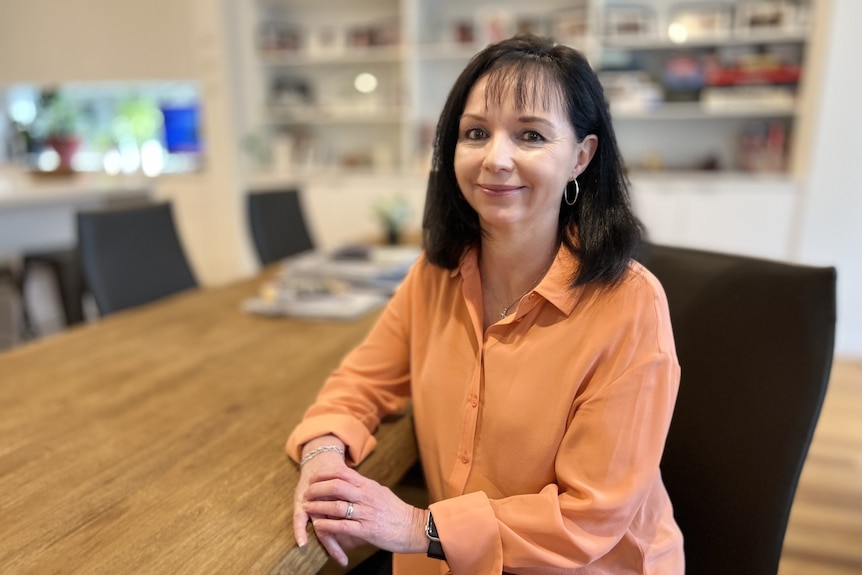 Dr Lisa Griffiths sits at her dining table inside her Melbourne home.