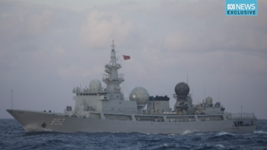 A military ship in the ocean, with a Chinese flag on it.