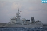 A military ship in the ocean, with a Chinese flag on it.