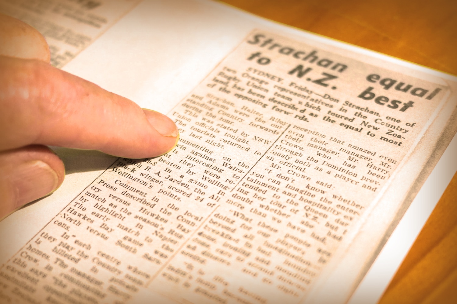 A finger pointing at a news article