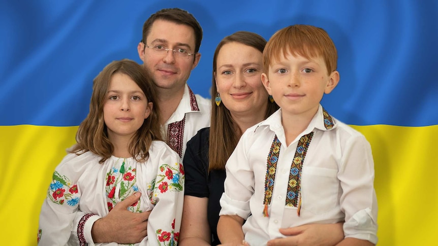 A Ukrainian Australian family posing on a background of the Ukrainian flag.