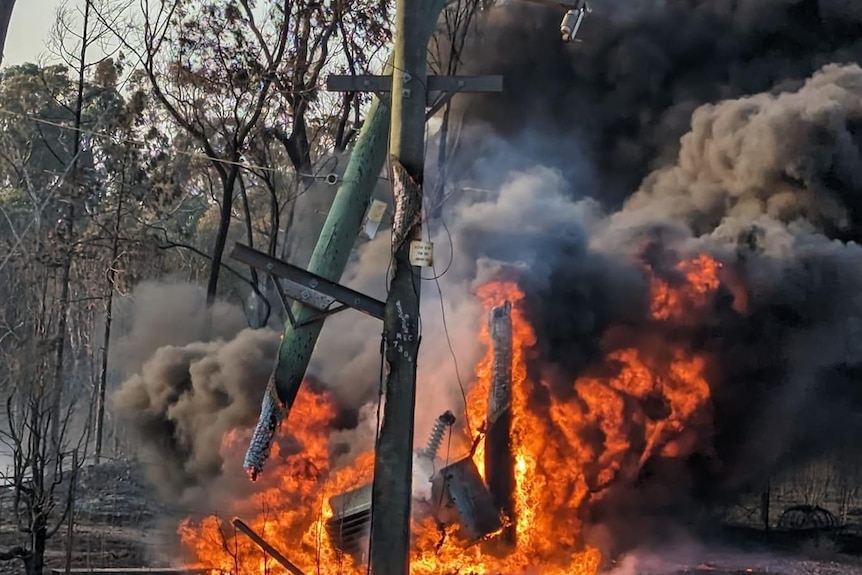 A power pole falls over during a fire