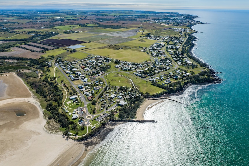 Aerial drone shot of a coastal community and blue sea water