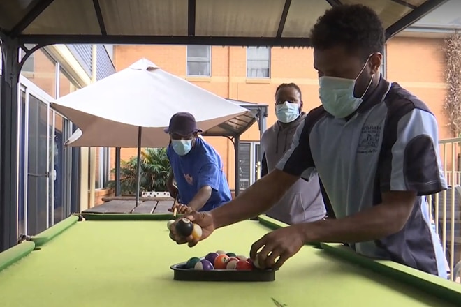 Three men playing pool