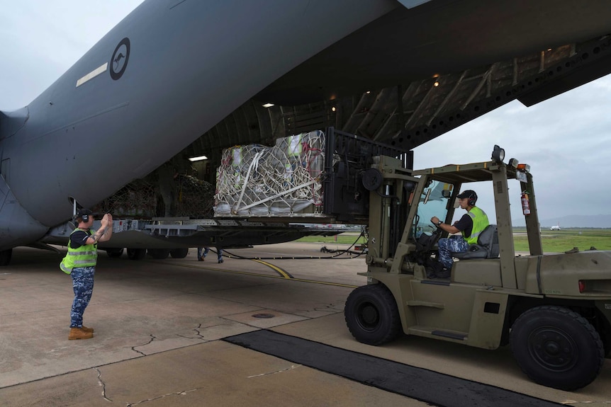 Members of the Australian Air Force use a forklift to load supplies onto a plane in Townsville.