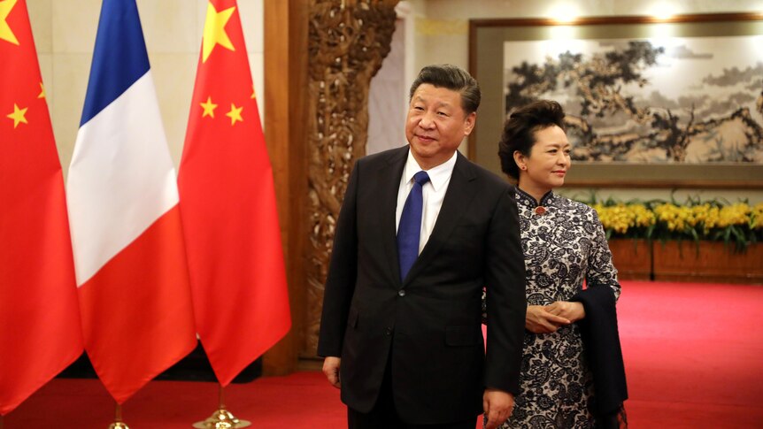 Peng Liyuan stands at the back of Xi Jinping. 