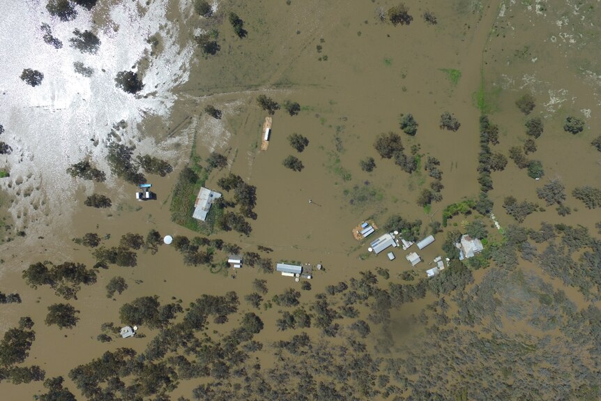 L'image d'un drone montre une vue à vol d'oiseau d'une maison complètement entourée par les eaux de crue