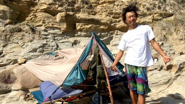 Toru standing in front of a tent on the rocks near Bulli.