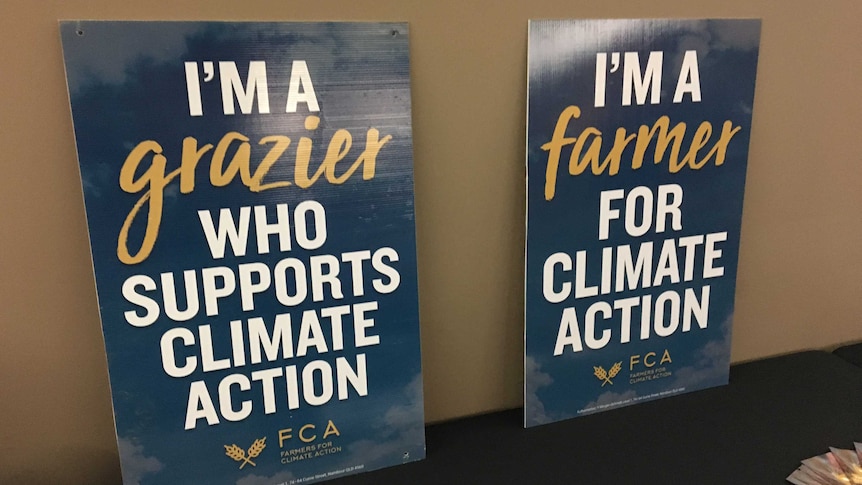 Two signs sitting on a table urging action on climate change