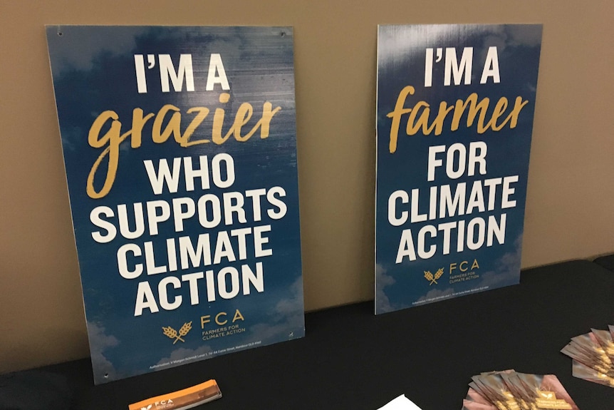 Two signs sitting on a table urging action on climate change