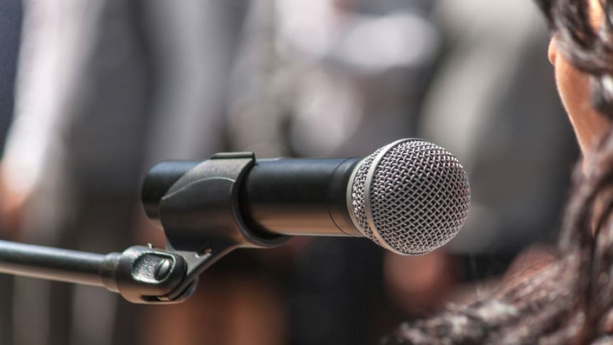 A woman speaking into a microphone