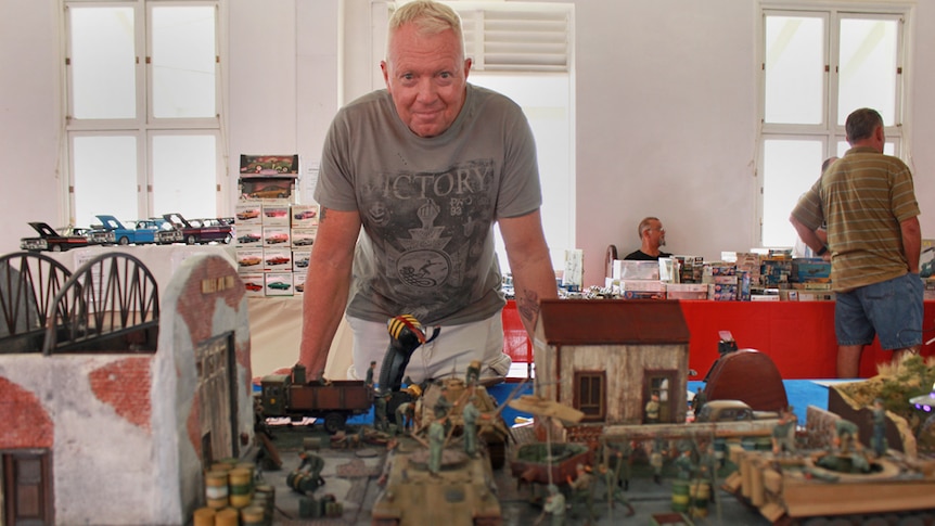 Mark Smith standing behind his scale model in Mackay