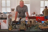 Mark Smith standing behind his scale model in Mackay