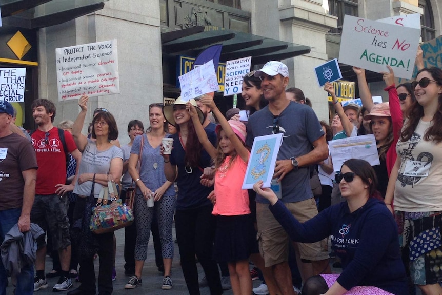 People at the Perth March for Science hold up homemade placards, including one that reads: "Science has no agenda!"