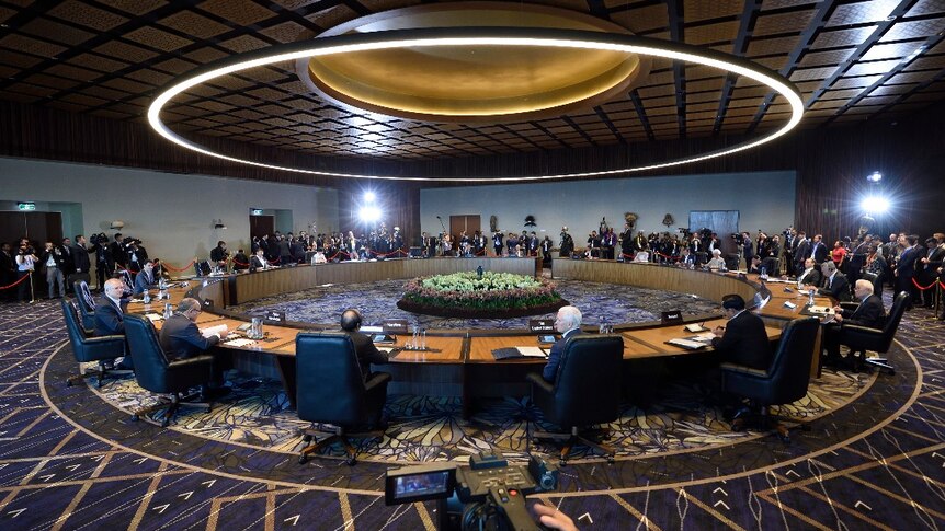 The shot of the round desk is the leaders meeting underway at 2018 APEC Economic Leaders' Meeting Haus.