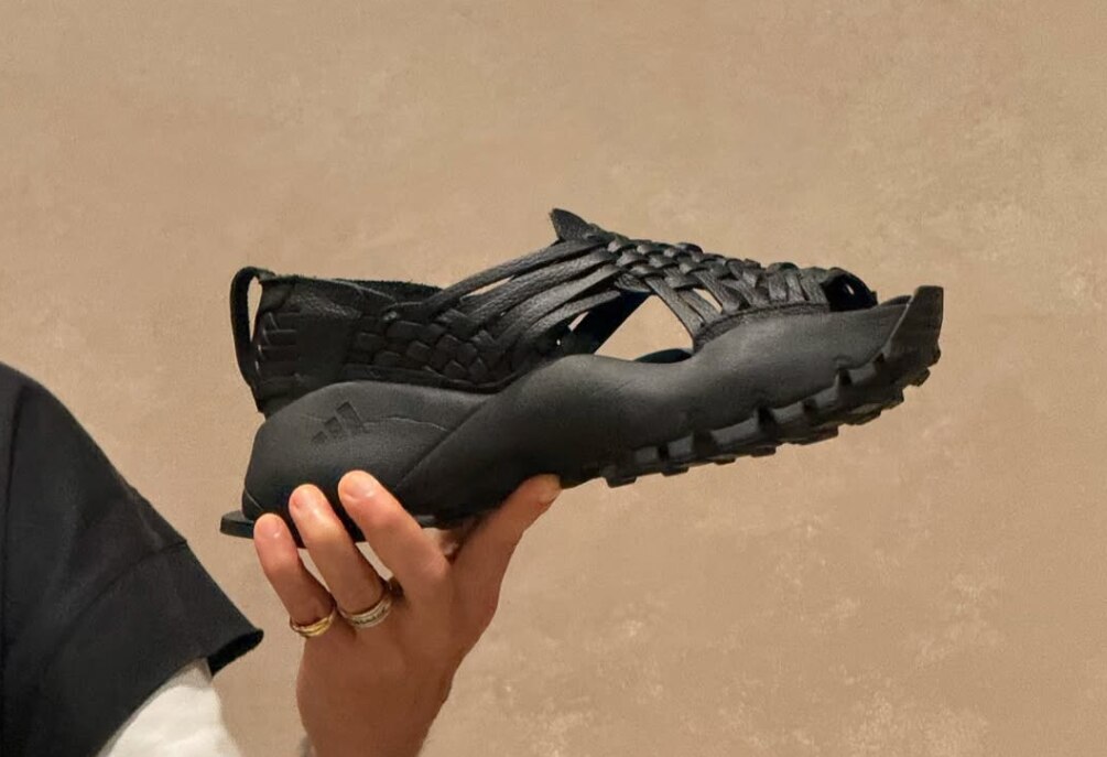 A hand holds a black shoe 