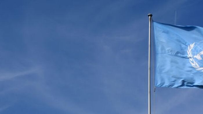 United Nations flag flying outside Geneva UN headquarters.