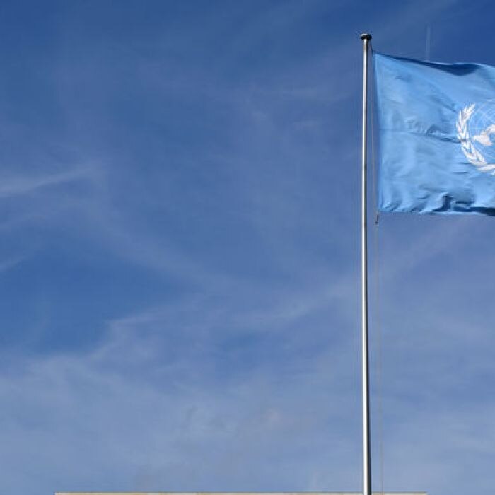 United Nations flag flying outside Geneva UN headquarters.