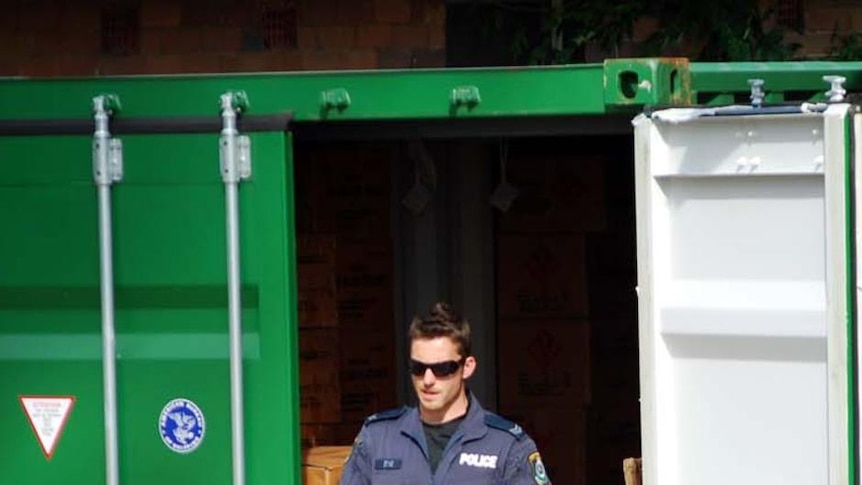 A police officer carries a box filled with fireworks