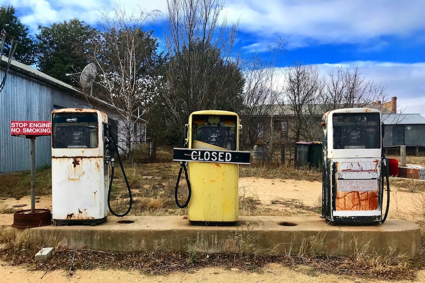 3 old rusty petrol bowsers in a row