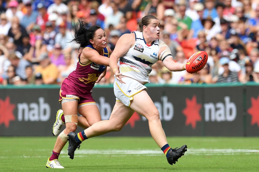 Sarah Perkins runs away from the Lions' defence