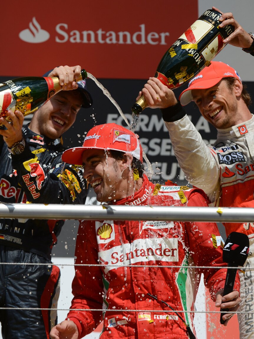 Fernando Alonso (c) gets the champagne treatment in Germany.