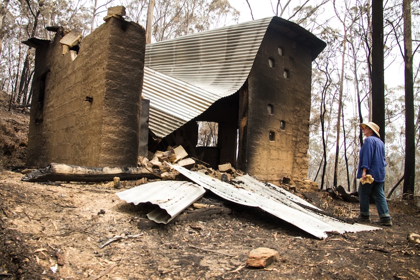 The remains of a building consisting of bricks and corrugated iron after a bushfire.