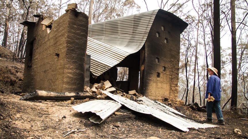 A woman looks at her burnt out studio.