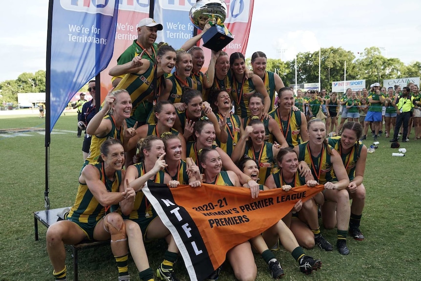 PINT players celebrate with the premiership cup after winning the 2020/21 NTFL Women's Premier League grand final.