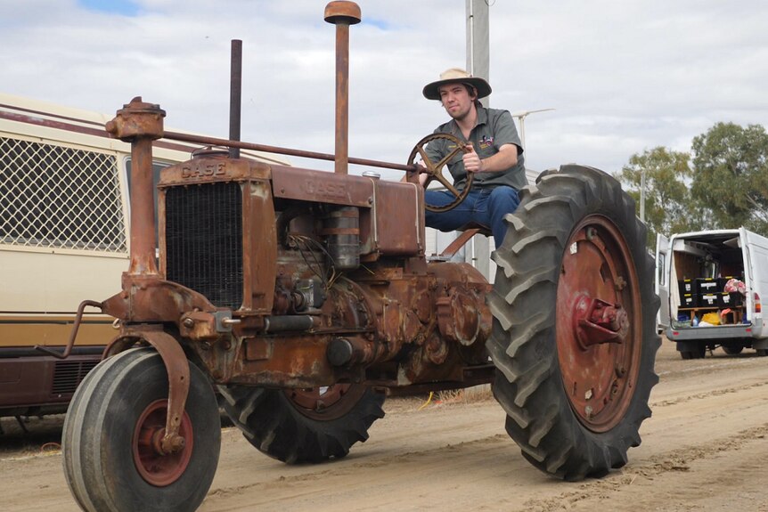 James Mergard sits on a vintage tractor