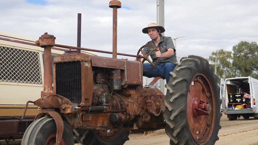 James Mergard sits on a vintage tractor