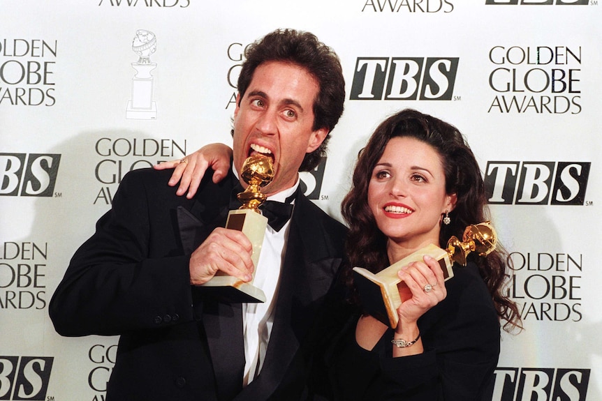 Jerry Seinfeld and Julia Louis-Dreyfus holding Golden Globes.