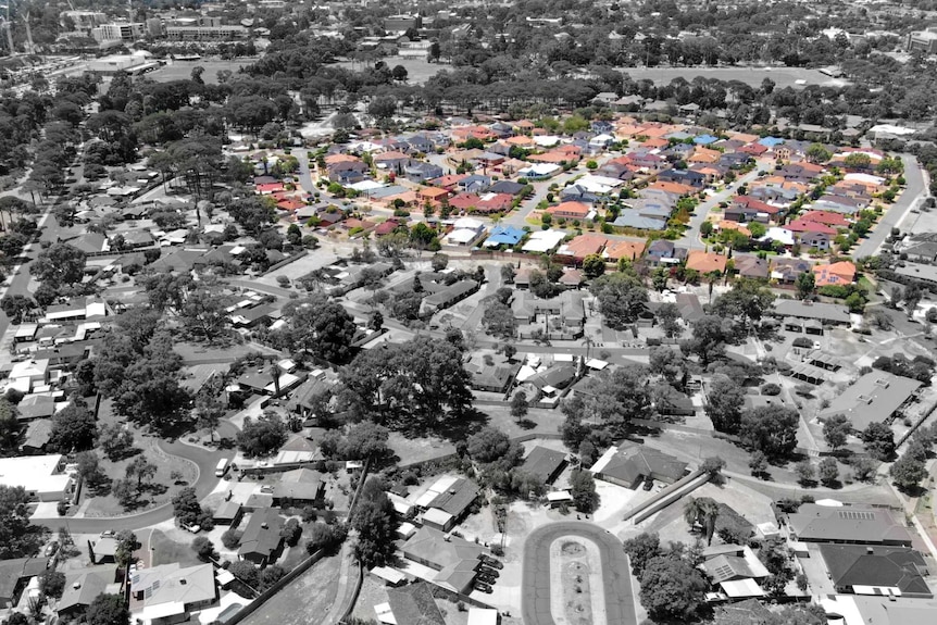 A black and white aerial view of a neighbourhood with a renovated section marked in colour