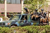 Troops ride in a vehicle near the French Embassy in central Ouagadougou, Burkina Faso,