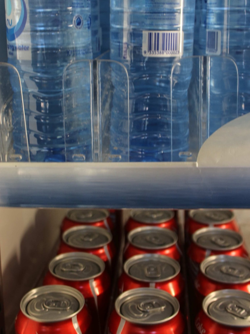 Generic image of bottled water and soft drink cans in fridge