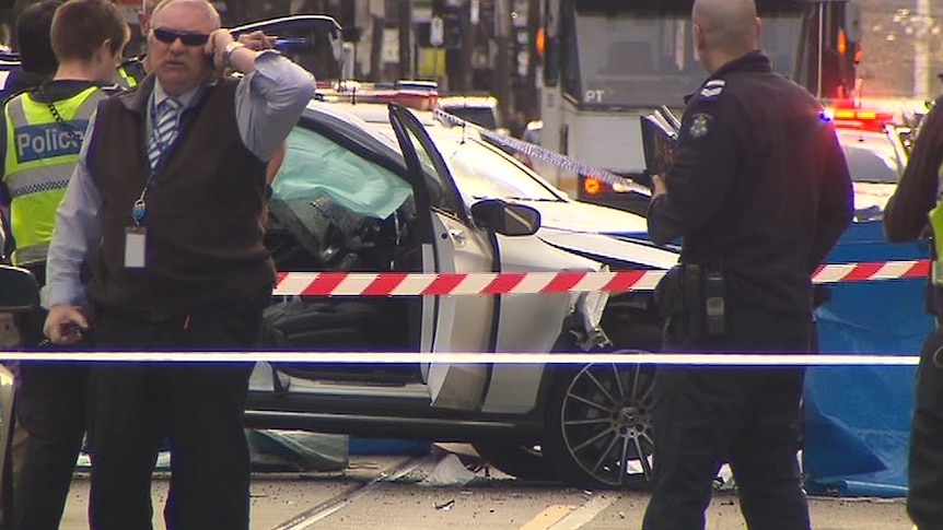 Police are seen around a smashed-up white Mercedes on Chapel Street.