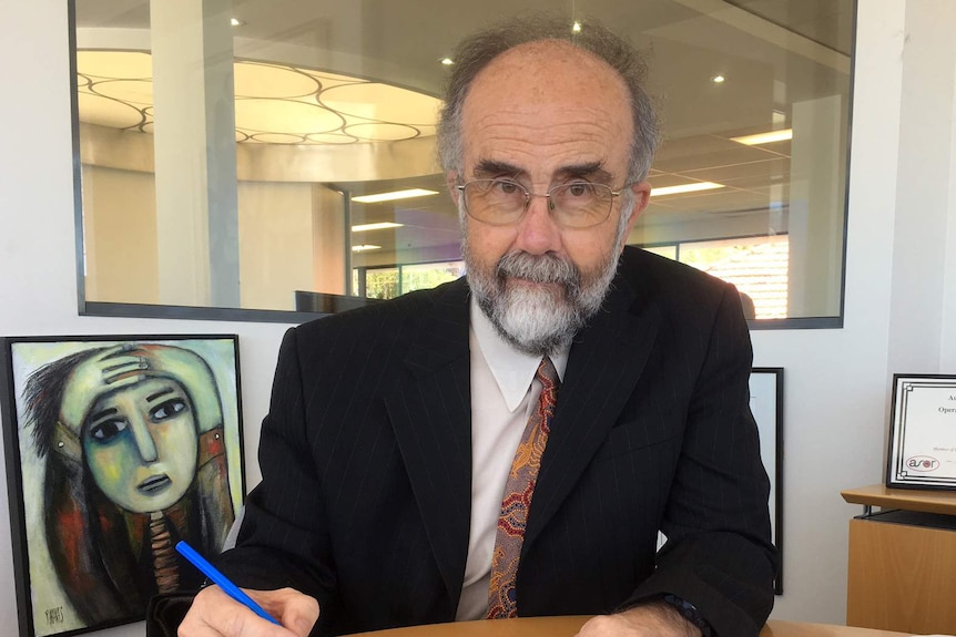 Statistician John Henstridge sitting at a desk