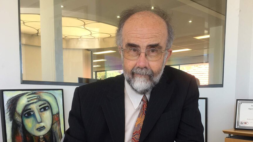 Statistician John Henstridge sitting at a desk