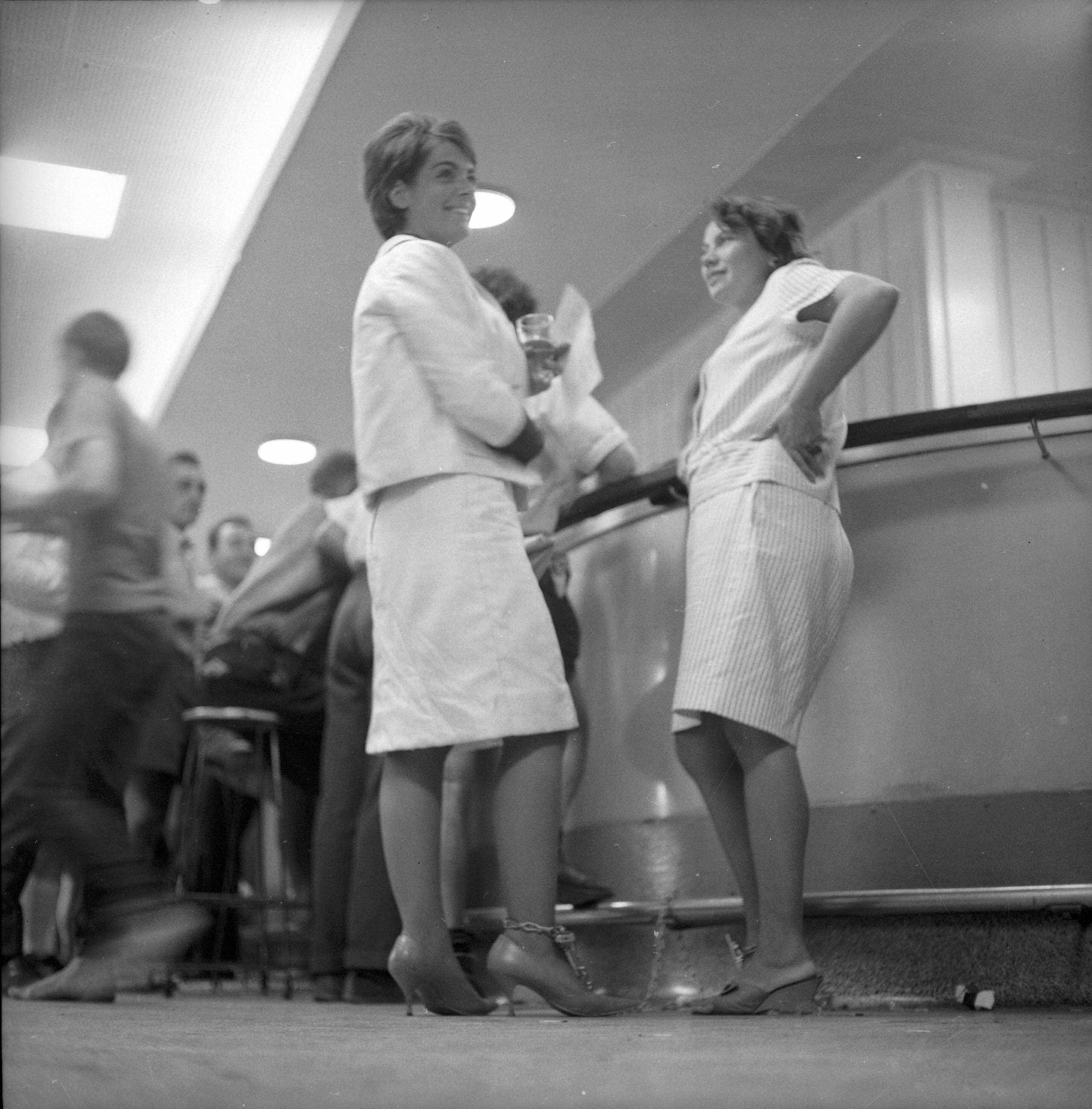 Black and white picture of two women chained to a bar 
