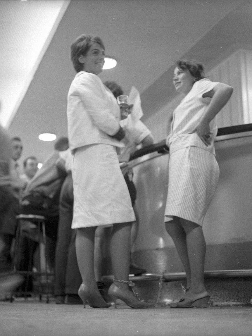 Black and white picture of two women chained to the bar 
