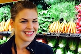 Belle Gibson stands next to fruit and vegetables in a shop.