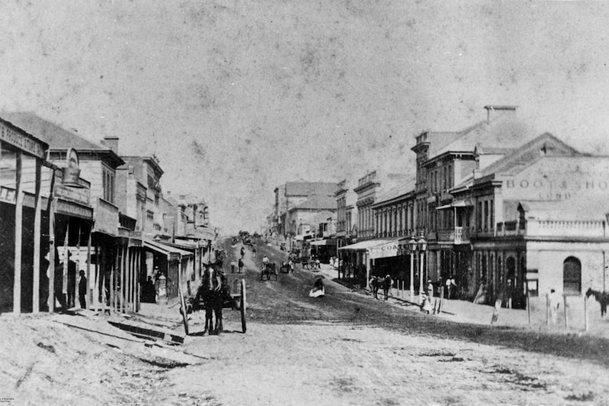 Black and white city street photo with horse and carriage