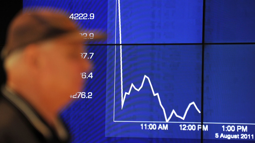 Passers-by watch the share market plunge on an Australian Stock Exchange graph in Sydney on August 5, 2011.