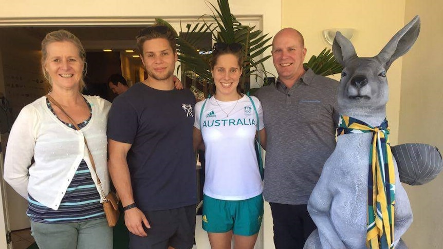 Four people standing side by side, with a large toy kangaroo mascot.