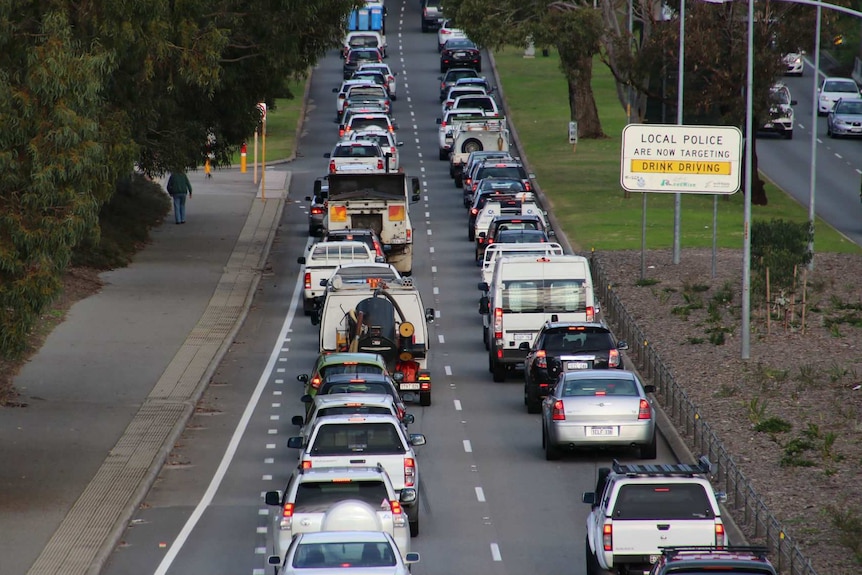 Two lanes of traffic banked up in peak hour traffic.