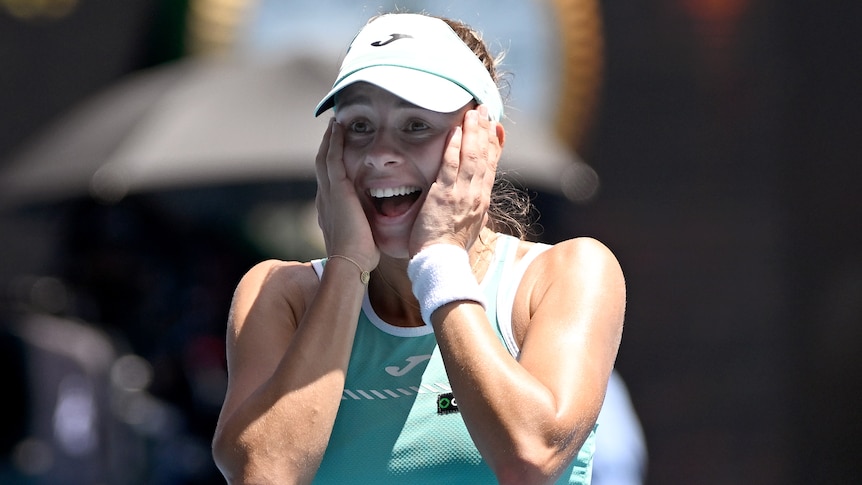 A Polish female tennis player holds her face as she celebrates victory in the quarterfinals at the Australian Open.