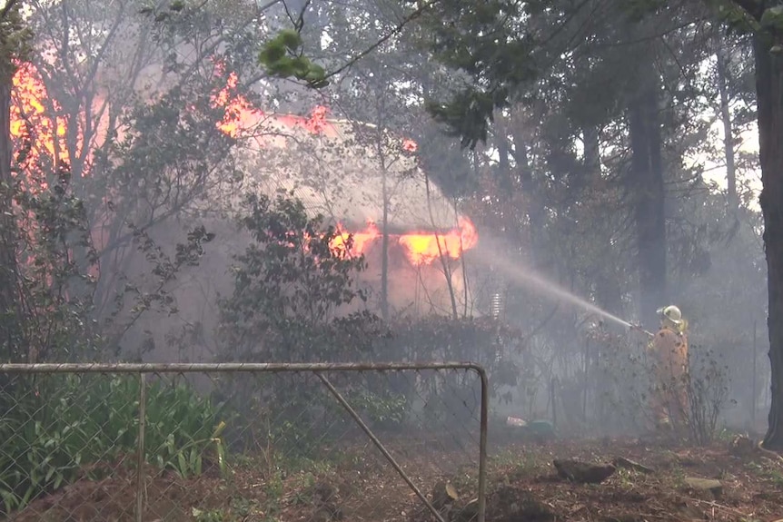 A firefighter sprays water at a fire.