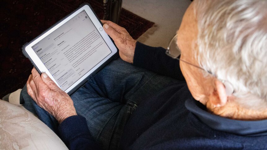 Older man views emails on iPad